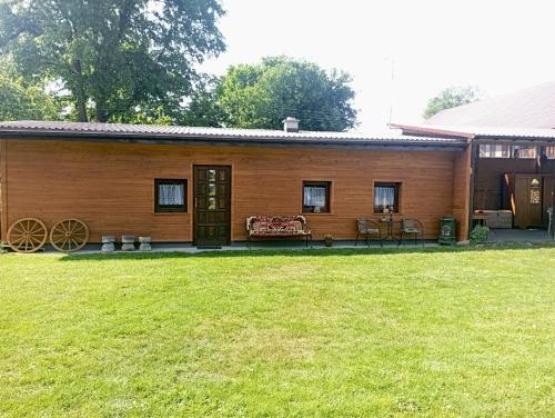 a wooden cabin with a lawn in front of it at Sołtysówka in Wólka Nadbużna