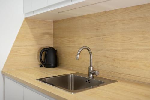 a kitchen counter with a stainless steel sink at Apartman Oliva and Studio Delux for a family with swiming pool, free parking, terace with view at the sea in Podstrana