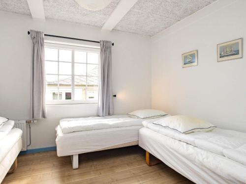 two beds in a room with a window at 10 person holiday home in Marstal-By Traum in Marstal