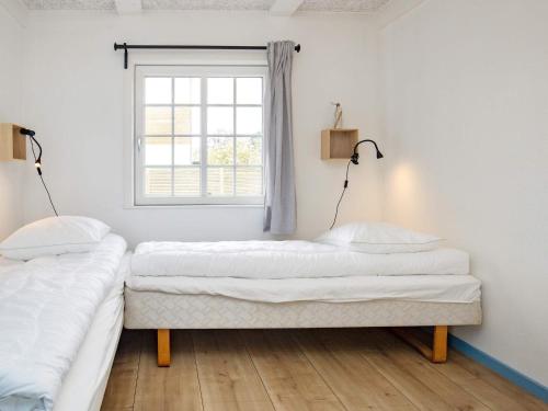 two beds in a room with a window at 10 person holiday home in Marstal-By Traum in Marstal
