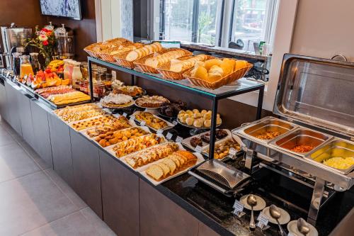 uma linha de buffet com muitos tipos diferentes de pastelarias em Edícula Cambará em Cambará