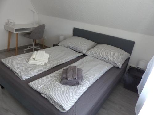 Una cama con dos toallas y una bolsa. en Ferienwohnung, en Porta Westfalica