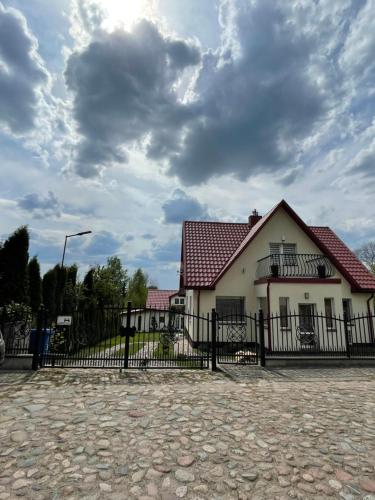 a house with a fence in front of it at Mėta House in Merkinė