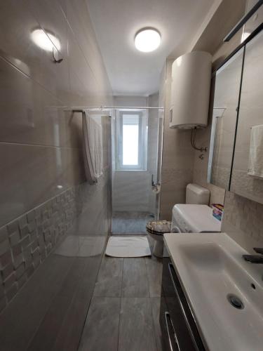 een badkamer met een douche, een wastafel en een toilet bij Marie in Zadar