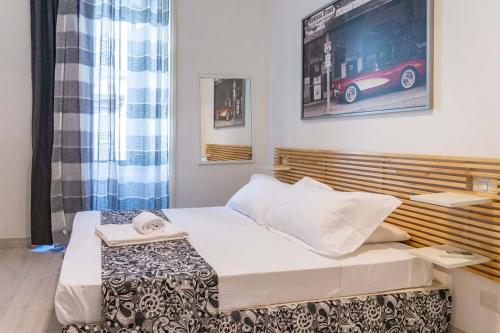 Un pequeño dormitorio con una cama y una foto de un coche en la pared en Le suite di Borgo en Roma