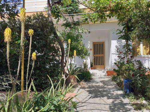 a white house with a pathway leading to a door at Kampos Rooms in Palaiochóra