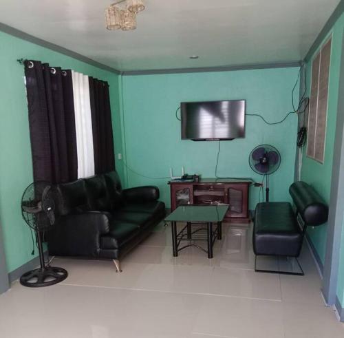 a living room with a couch and a tv at AB Yam Staycation Gensan near Venue88 in General Santos