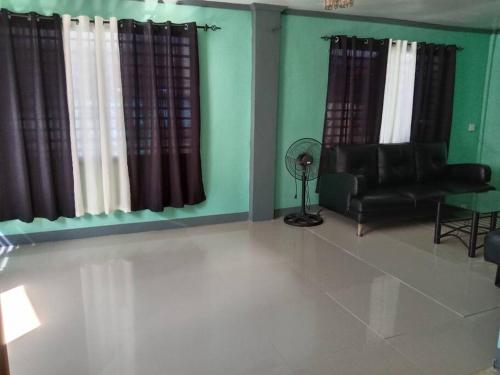 a living room with a couch and a chair at AB Yam Staycation Gensan near Venue88 in General Santos