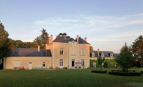une grande maison avec une grande pelouse dans l'établissement Le Château de Leugny, à Oiron