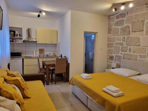 um pequeno quarto com 2 camas e uma cozinha em Guest House Renata1 em Zadar