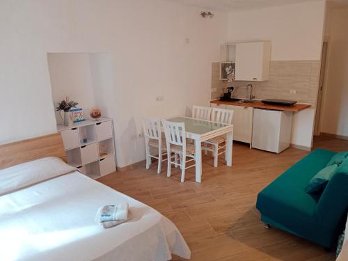 Habitación con cama, mesa y cocina. en Alghero d'Estate en Alguer