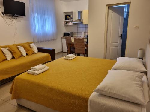 Dos camas en una habitación de hotel con toallas. en Guest House Renata1 en Zadar