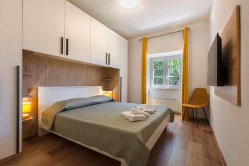 a bedroom with a bed with two towels on it at Casa Laurales in Veli Turini
