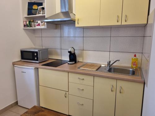 una pequeña cocina con fregadero y microondas en Guest House Renata1 en Zadar
