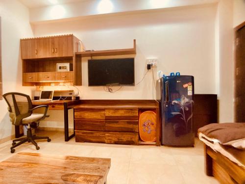 a room with a desk and a refrigerator in a room at Apartment In Mumbai City Centre in Mumbai