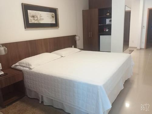 a bedroom with a large white bed in a room at Excellence Plaza Hotel in Botucatu