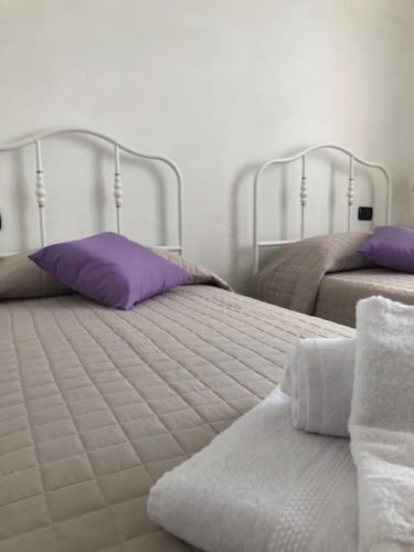 una camera con due letti, asciugamani e cuscini di Il giardino delle rose a Spello