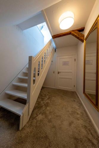 a staircase in a room with a mirror and a door at Romantik Hotel Friederikenhof Hotel Restaurant & Spa in Lübeck
