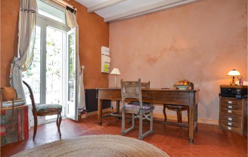 Zimmer mit einem Holzschreibtisch und 2 Stühlen in der Unterkunft Gorgeous Home In Aramon With Kitchen in Aramon