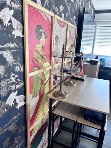 una habitación con una mesa y una pintura en la pared en LE GEISHA, en La Grande-Motte