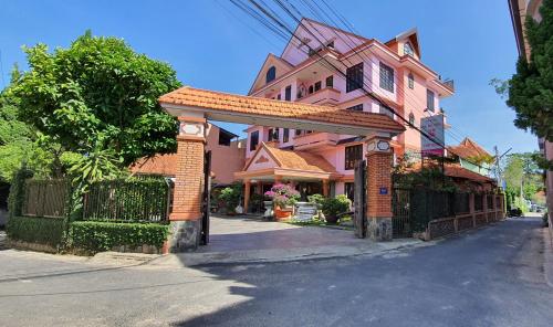 une maison rose avec une porte dans une rue dans l'établissement Villa Pink House, à Đà Lạt