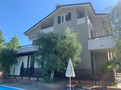 a house with an umbrella next to a swimming pool at Villarobinia in Lazise