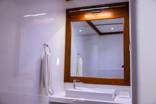 a bathroom with a sink and a mirror at Ceylonta Beach Resort in Hambantota