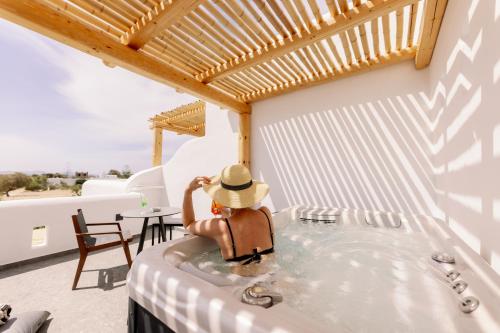 a man in a jacuzzi tub on a patio at Naxian Secret in Naxos Chora