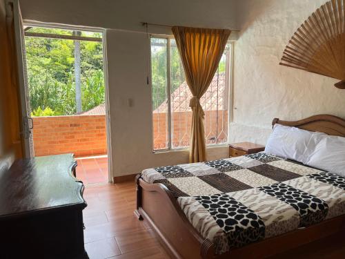 a bedroom with a bed and a large window at Cabaña milenio 1 in Moniquirá