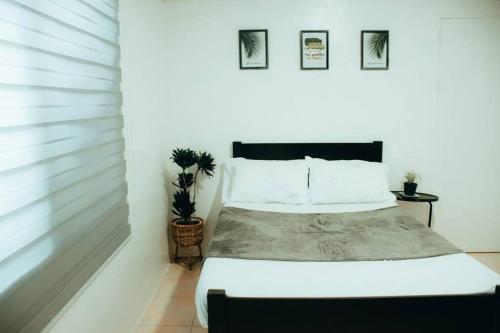 um quarto com uma cama com paredes brancas em Relaxing & Accessible Apartment em Matinkanana