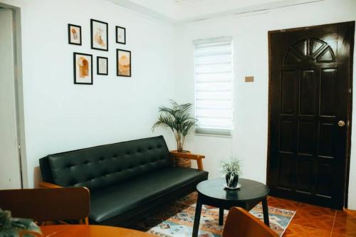 a living room with a black couch and a table at Relaxing & Accessible Apartment in Matinkanana