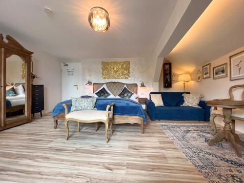 1 dormitorio con 1 cama azul y 1 sofá azul en Sieben Zimmer am See, en Prien am Chiemsee