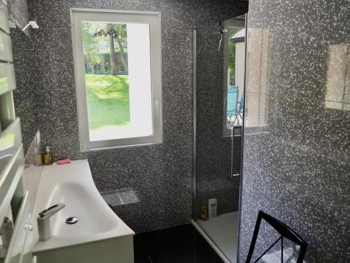 une salle de bain avec un lavabo et une fenêtre dans l'établissement Les Héliades, à Le Touquet-Paris-Plage