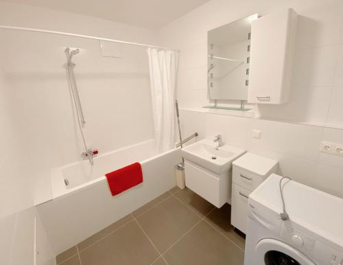 a white bathroom with a sink and a toilet at U1 Alte Donau old Danube city apartment 2 in Vienna