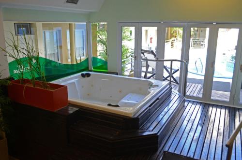 a large bath tub sitting on top of a deck at Hotel Suite & Spa Verdesolaro in Villa Elisa