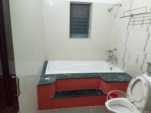 een badkamer met een bad en een toilet bij HOTEL MTM in Digha