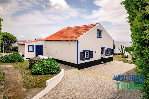 a small white house with a red roof at Casa da Rocha in Santa Bárbara