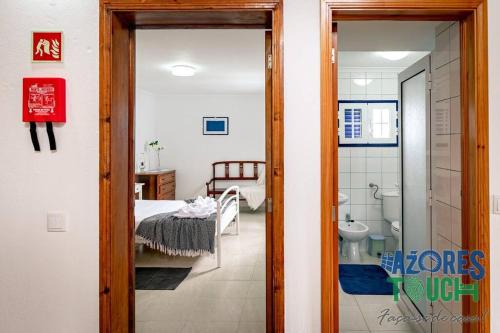 a room with a bedroom with a bed and a bathroom at Casa da Rocha in Angra do Heroísmo