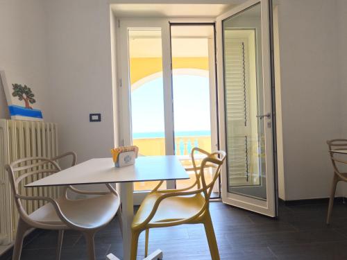 a table and chairs in a room with a balcony at B&B The Sun 'tis in Castro di Lecce