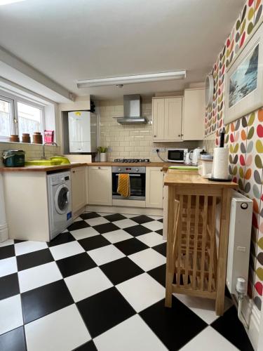 a kitchen with a black and white checkered floor at Oyster Cottage in The Mumbles