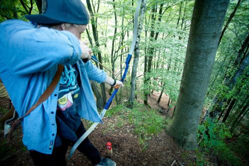 a person walking through the woods with a stick at Schwimmbad Camping Mössler in Döbriach