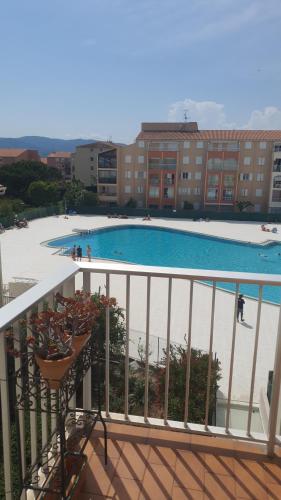 een balkon met uitzicht op een zwembad bij Appartement très agréable in Fréjus