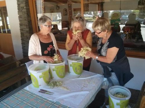 three women standing around a table eating food at Schwimmbad Camping Mössler in Döbriach