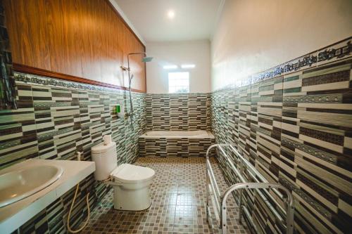 een badkamer met een toilet, een wastafel en een bad bij Pondok Ubud Nia Cahya in Tegalalang