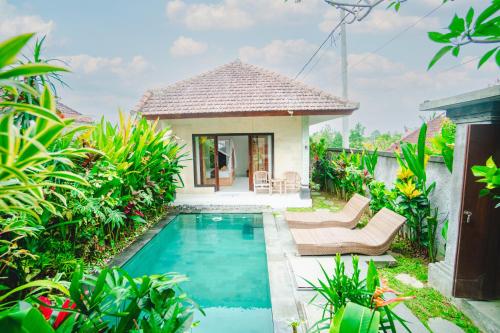 a villa with a swimming pool and a house at Pondok Ubud Nia Cahya in Tegalalang