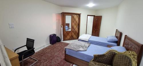 um quarto com 2 camas, uma secretária e uma televisão em ستوديو على البحر محطة الرمل Raml station stodeo em Alexandria