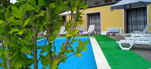 a resort with a pool and chairs and trees at Casa do Toucedo - Encanto da Natureza Caniçada / Gerês in Caniçada
