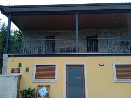 a house with a balcony and a door at Casa do Toucedo - Encanto da Natureza Caniçada / Gerês in Caniçada