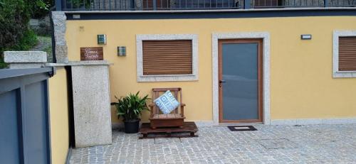 a yellow house with a door and a plant in front of it at Casa do Toucedo - Encanto da Natureza Caniçada / Gerês in Caniçada