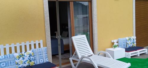a pair of white chairs sitting on a porch at Casa do Toucedo - Encanto da Natureza Caniçada / Gerês in Caniçada